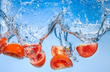 Tomato. Vegetables fall deeply under water with a big splash clipart