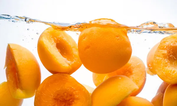 Canned peaches. Preserved fruit splash in water — Stock Photo, Image