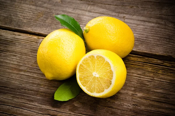 Fresh organic fruit - lemons on wood background selective focus — Stock Photo, Image