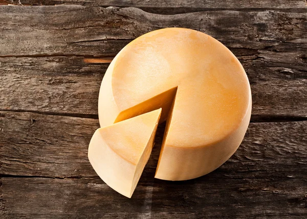 木製のテーブルの上のチーズのホイール — ストック写真
