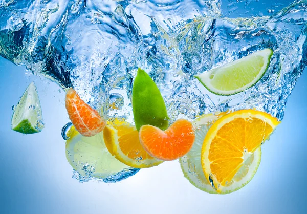 Tropical fruits fall deeply under water with a big splash — Stock Photo, Image