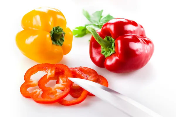 Colored peppers with slice over white background — Stock Photo, Image