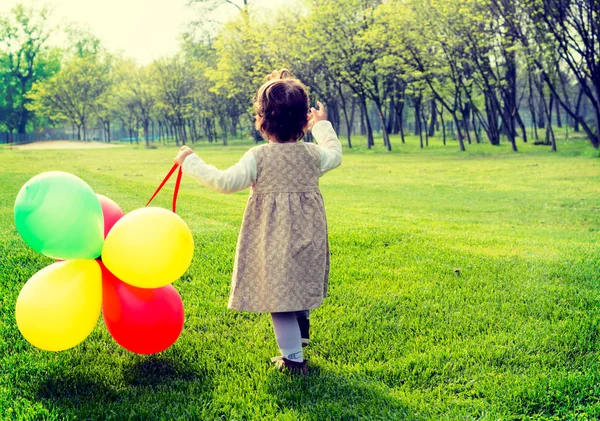 Ребенок с воздушными шарами и прогулки в парке — стоковое фото