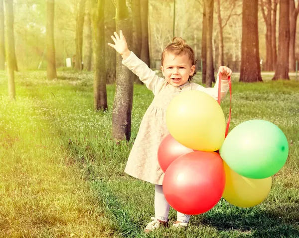 Niño con globos alcanzan el sol —  Fotos de Stock