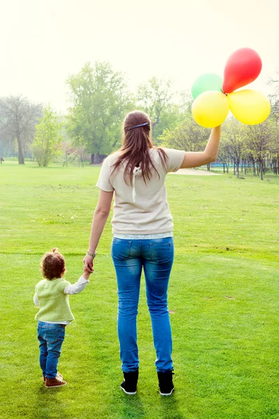 Mother and daughter holding balloons — Stock Photo, Image