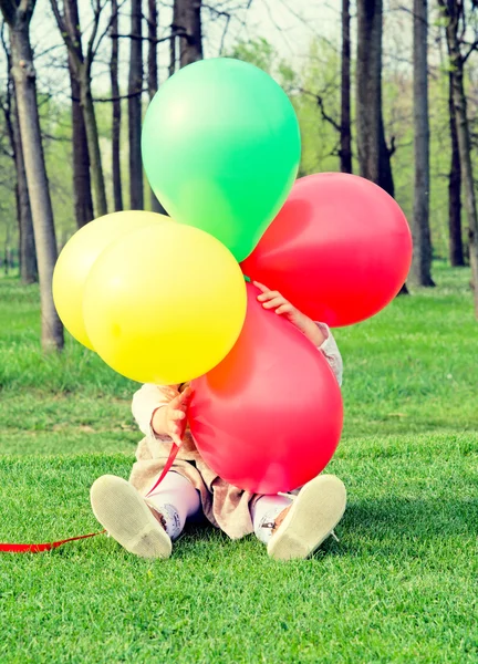 Niño escondido detrás de globos —  Fotos de Stock