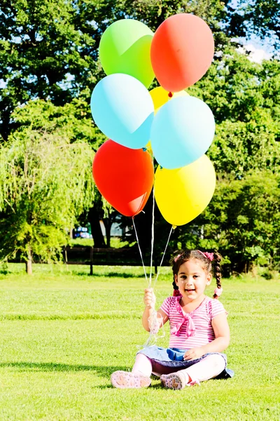 Mała dziewczynka gospodarstwa kolorowe balony — Zdjęcie stockowe