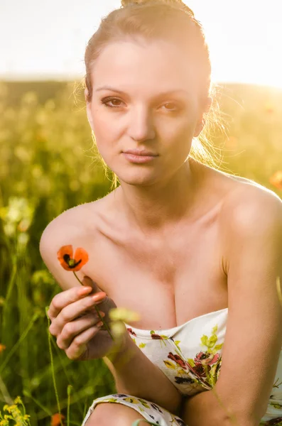 Jeune femme champ de pavot au coucher du soleil — Photo