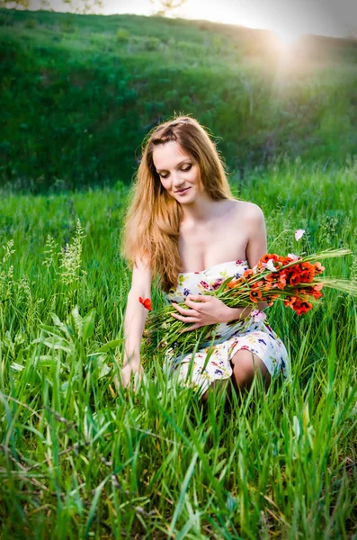 Jeune femme cueillette de fleurs de pavot Photo De Stock