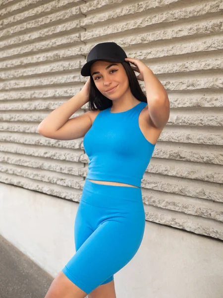 Positieve Jonge Latijns Amerikaanse Vrouw Blauwe Activewear Aanraken Pet Donker — Stockfoto