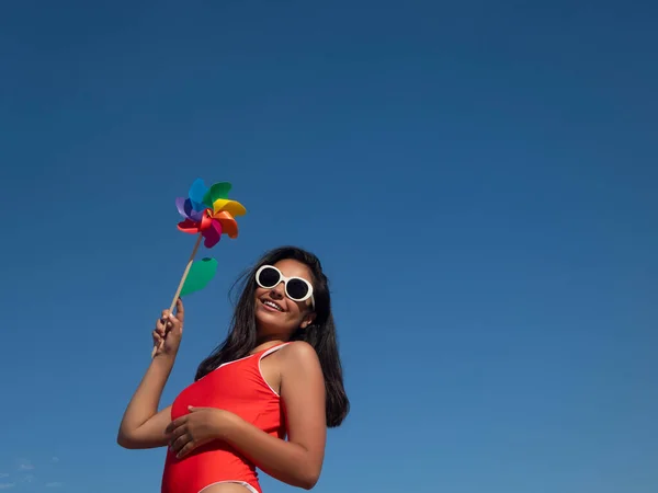 Positive Female Swimwear Holding Colorful Toy Windmill While Standing Cloudless — Stok fotoğraf