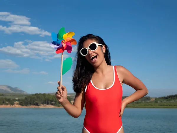 Delighted Female Swimwear Holding Pinwheel While Standing Opened Mouth Shore — Stok fotoğraf