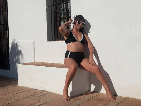 Full Body Barefoot Woman Swimwear Sunglasses Touching Wireless Headphones Smiling — Fotografia de Stock