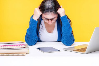 Genç bir kadın evde dizüstü bilgisayar ve not defteriyle çalışırken kendini ciddi hissediyor. İnternette e-öğrenim sistemi okuyor.