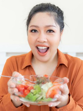 Aşırı kilolu Asyalı tombul kadın, sebze salatası yiyen şişman kadın - yaşam tarzı kadın diyet kilo kaybı sorunu kavramı