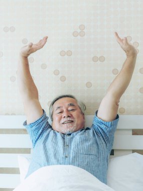 Son sınıf öğrencisi mutlu. Sağlıklı bir sabah uyanıp, yatak odasının arka planında eğleniyor. Son sınıf mutluluk kavramı.