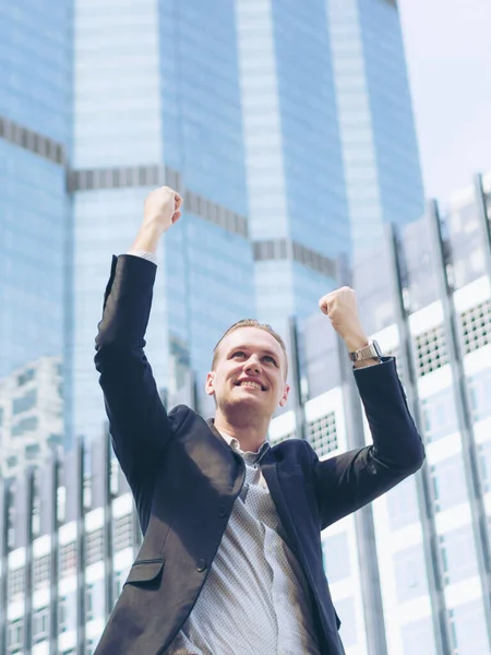 Başarılı bir iş adamı iş bölgesinde silahlarla kutlama yapıyor, iş kavramı