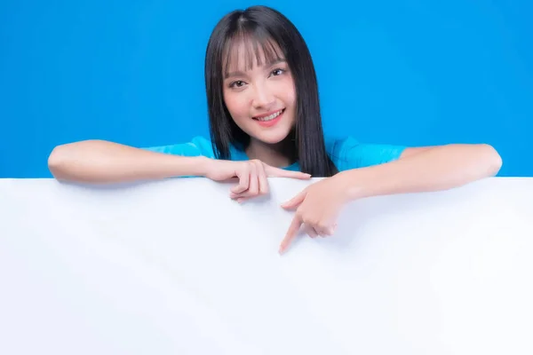 Mavi Tişörtlü Güzel Asyalı Genç Bir Kadın Gülümsüyor Işaret Ediyor — Stok fotoğraf