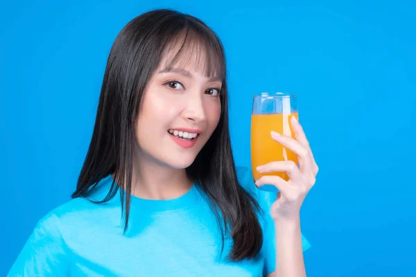 美しい美しさアジアの女性かわいい女の子とともに前髪のあるスタイルで青Tシャツ幸せな飲みオレンジジュースのための健康的な青の背景に ライフスタイルの美しさ女性の健康的なコンセプト — ストック写真
