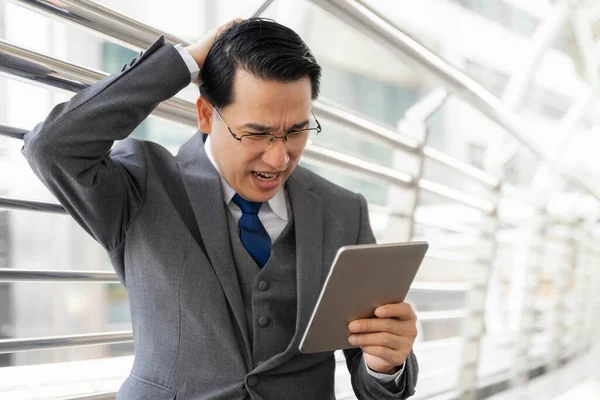 Gri takım elbiseli bir iş adamı, kötü haber aldıktan sonra stres ve hüsran dolu iş konseptinden muzdarip olduğu için işten dolayı stresli.