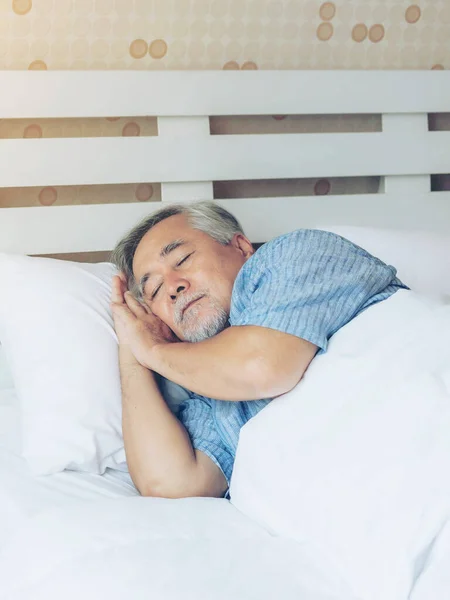 Senior male , old man sleeping on the pillow on white bed room in the morning - lifestyle senior male good health concept