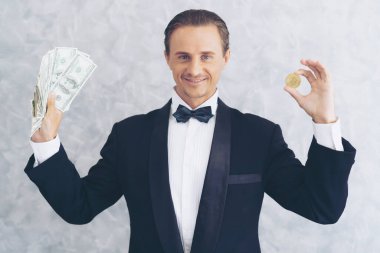 İş adamı zengini tüccar Bitcoin altın sikkesi tutuyor Bitcoin tüccarı için yeni para değişimi ve Amerikan doları banknotları - kripto döviz tüccarı iş konsepti