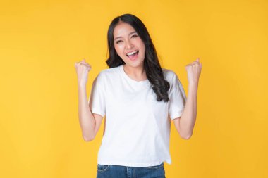 Sarı arka planda izole edilmiş, mutlu ve mutlu Asyalı bir kadının portresi.