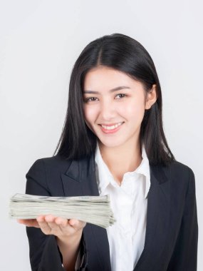 Başarılı bir Asyalı iş kadını elinde ABD dolarları ve iş konsepti tutuyor.