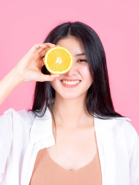 아시아 에사는 여자가 분홍색 배경의 건강에 오렌지 열매를 행복해 아름다운 — 스톡 사진