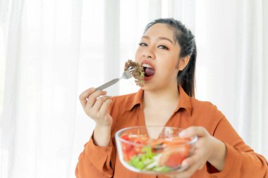 Kilolu Asyalı tombul kadın, şişman kadın, şişman kız, tombul, sebze salatası yiyen - yaşam tarzı kadın diyet zayıflama aşırı kilo verme sorunu kavramı