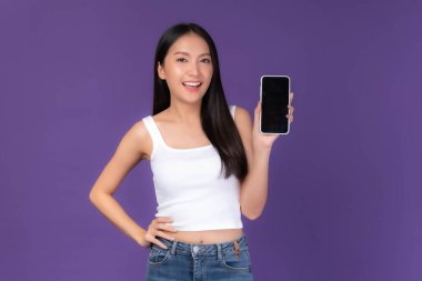 portrait of beautiful Asian young woman showing smart phone with blank screen , black screen isolated on purple background , Mock Up Image