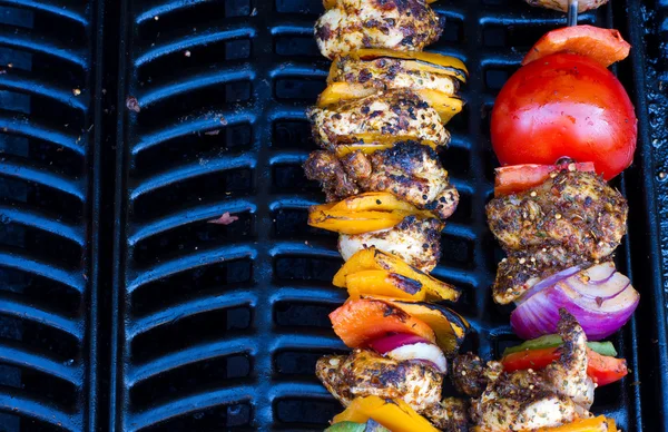 Chicken and pepper kebabs slowly cooking on the barbecue — Stock Photo, Image