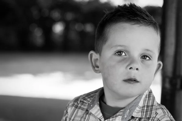 Портрет черно-белого мальчика в парке — стоковое фото