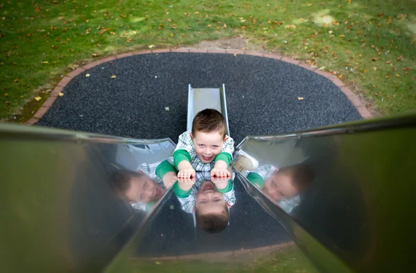 Little boy sliding down a side at the park — Stock Photo, Image