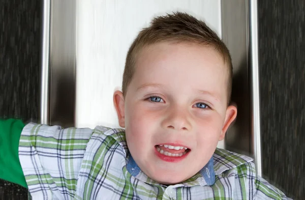 Kleine jongen glijdend van een kant in het park — Stockfoto