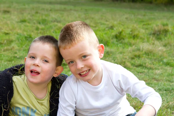 Twee broers glimlachend in de weide — Stockfoto