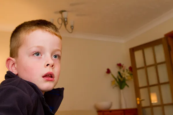 Petit garçon regardant la télévision dans le salon — Photo