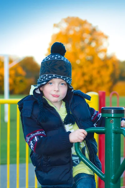 Kleine jongen spelen op appratus in het park — Stockfoto