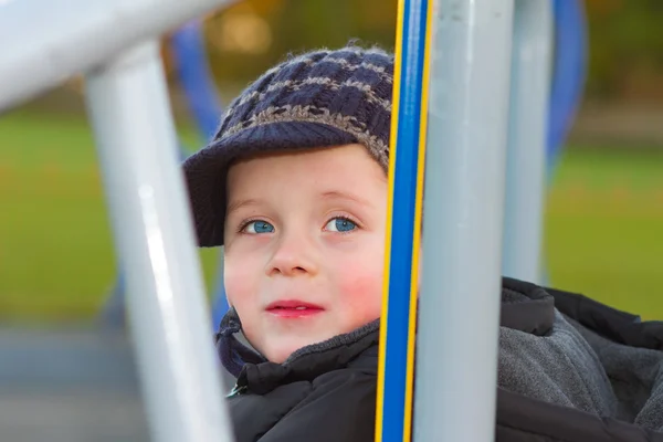 Petit garçon jouant sur appratus au parc — Photo