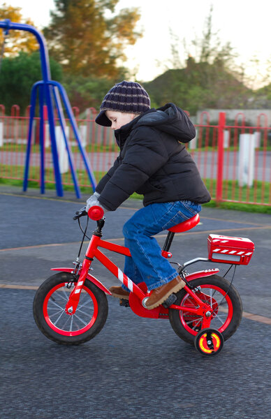 boy riding his bike through a park