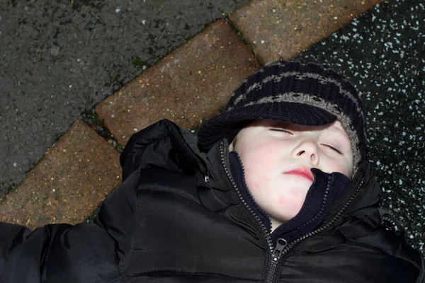 Litte boy knocked down outside oon tarmac — Stock Photo, Image