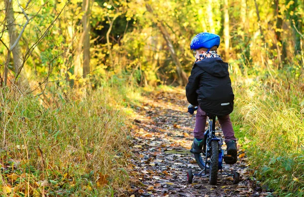 Kleiner Junge fährt mit dem Fahrrad durch Waldweg — Stockfoto