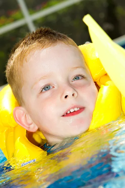 Kleiner Junge schwimmt mit Schwimmweste an — Stockfoto