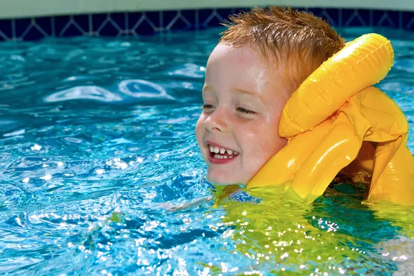 Kleiner Junge schwimmt mit Schwimmweste an — Stockfoto