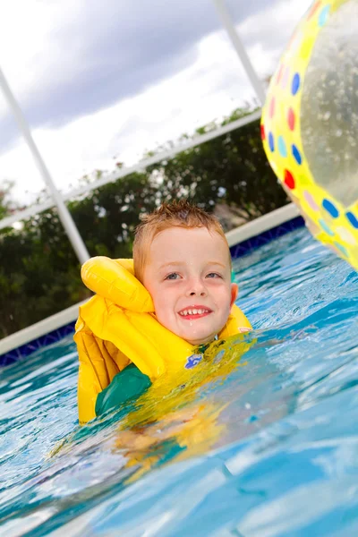 Kleiner Junge schwimmt mit Schwimmweste an — Stockfoto