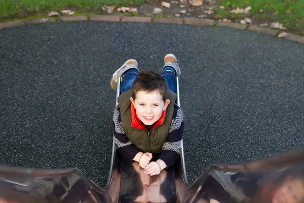 Glad liten pojke glida ner en bild på park — Stockfoto