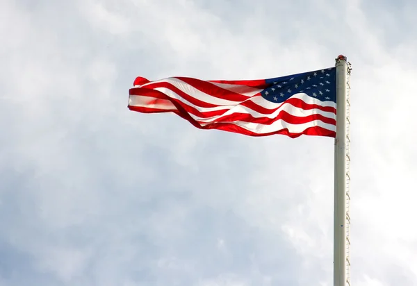 American flag on pole with cloudy overcast sky — Stock Photo, Image