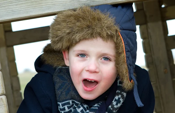 Glad ung pojke leker i parken på en kall dag — Stockfoto