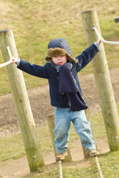 Щасливий молодий хлопчик грає в парку в холодний день — стокове фото