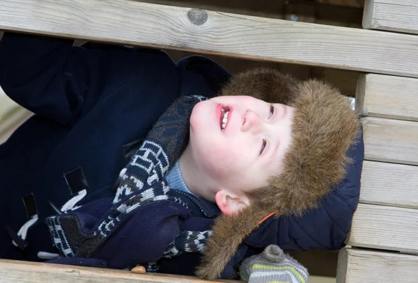 Happy young boy playing at the park on a cold day — Stock Photo, Image